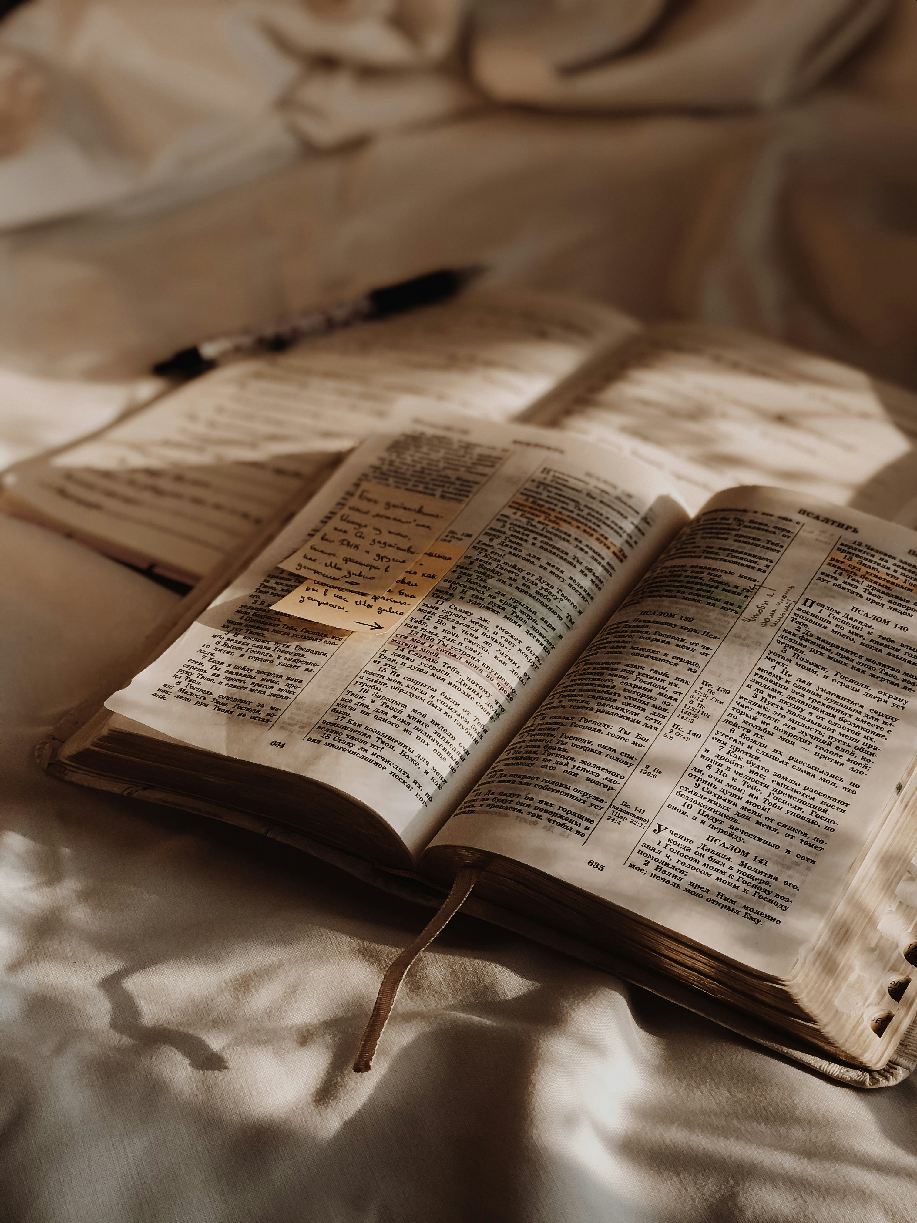 An open Bible resting on soft linen with warm morning light